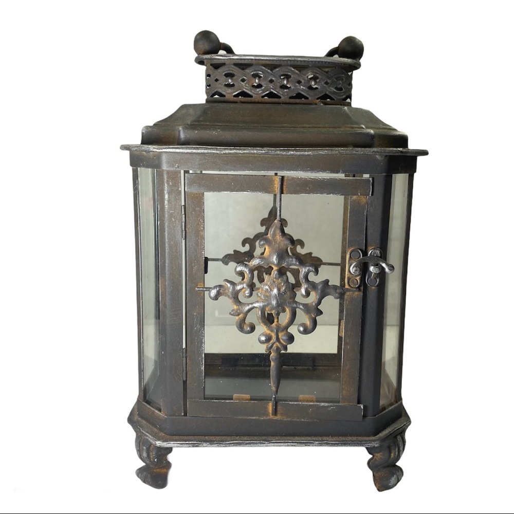 Rusty Iron Lantern with Scroll Embellishments.